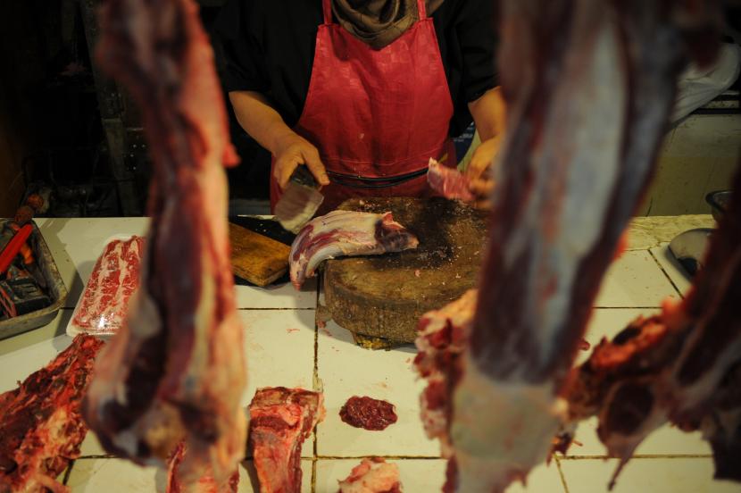 Pedagang memotong daging sapi di Pasar Kosambi, Bandung, Jawa Barat. Saat ini harga daging sapit tak terdampak PMK.