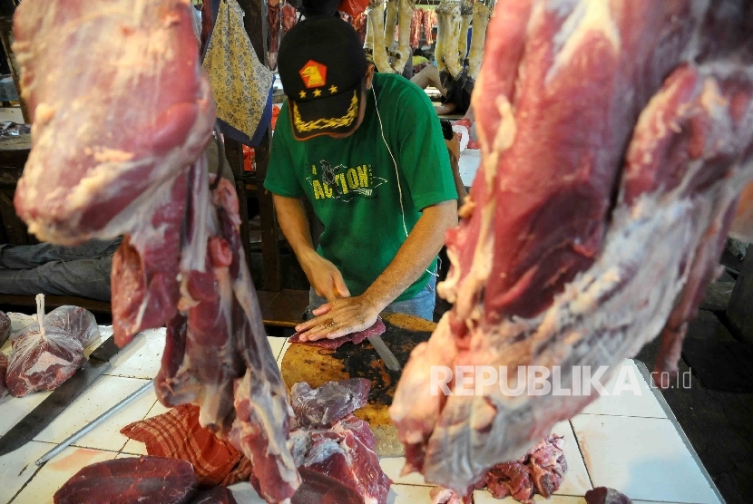  Pedagang memotong daging sapi di pasar tradisional.