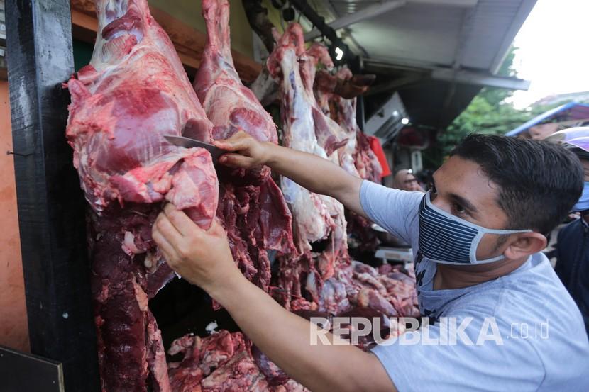 Pedagang memotong daging yang dijajakan. ilustrasi