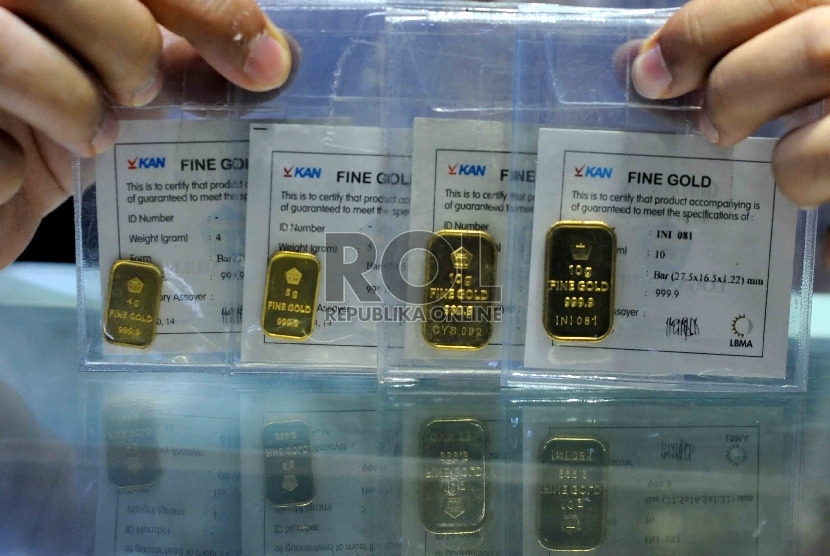 Pedagang memperlihatkan emas batangan di Pasar Tebet Jakarta, Selasa (13/10). 