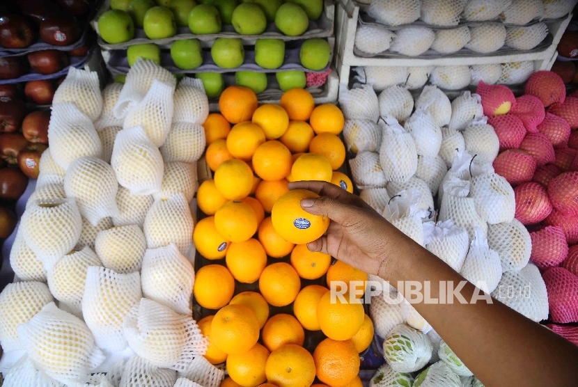 Pedagang menata buah di Pasar Jatinegara, Jakarta, Selasa (30/11). Buah impor hingga kini masih mendominasi pasar di Indonesia, dimana volume impor buah tahun 2015 mencapai 344.221 ton dengan nilai impor sebesar 543,83 juta AS sementara volume ekspor buah 