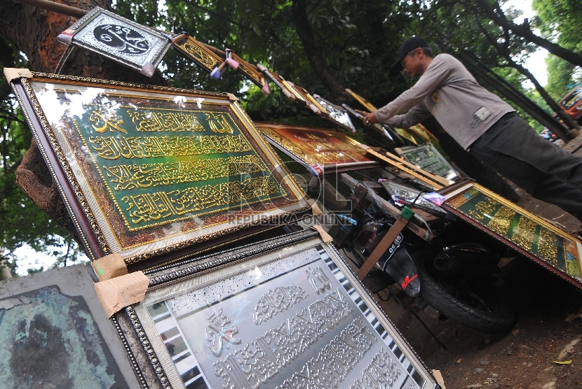 Pedagang menata hiasan kaligrafi dinding yang dijajakan di pinggir jalan Pondok Gede, Jakarta Timur, Kamis (9/4).