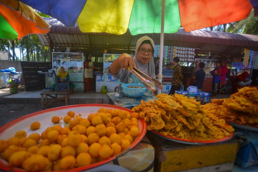 Pedagang menata kuliner Sala Lauak (gorengan khas Pariaman) yang dijualnya di Pantai Gandoriah, Pariaman, Sumatera Barat, Kamis (24/3/2022). Pedagang mengeluhkan sulitnya mencari minyak goreng di daerah itu dan harganya mahal, sehingga mereka terpaksa mengurangi produksi tanpa menaikan harga
