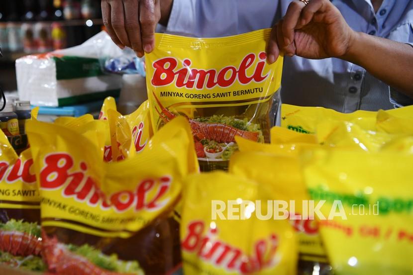 Pedagang menata minyak goreng kemasan di kiosnya di pasar. Pasokan minyak goreng HET di Bali terbatas.
