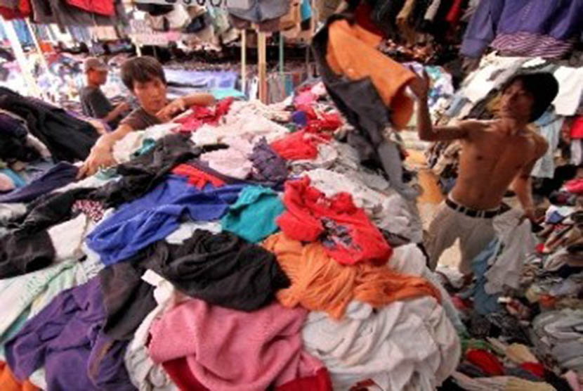 Pedagang menata pakaian bekas impor yang dijual di arena pasar malam. (ilustrasi). 