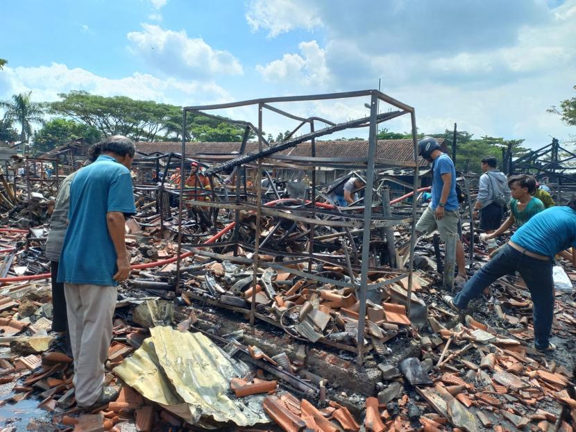 Pedagang mencari barang yang masih dapat diselamatkan selepas kebakaran di Pasar Besi Cikurubuk, Kota Tasikmalaya, Rabu (4/1/2023). 