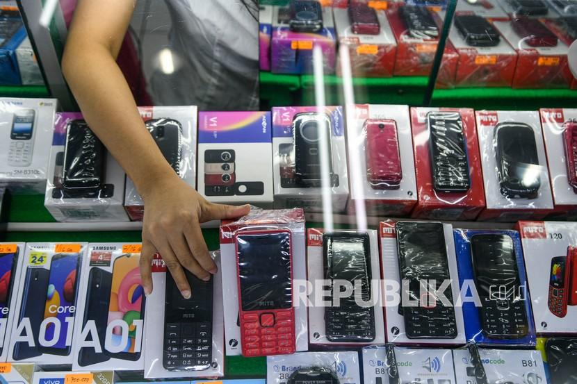 Pedagang mengambil salah satu ponsel di salah satu gerai Jakarta.