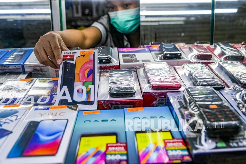 Pedagang mengambil salah satu ponsel di salah satu gerai di Metro Atom, Jakarta, Kamis (20/8/2020). Survei Populix menunjukkan responden cenderung memilih membayar tunai saat membeli ponsel.