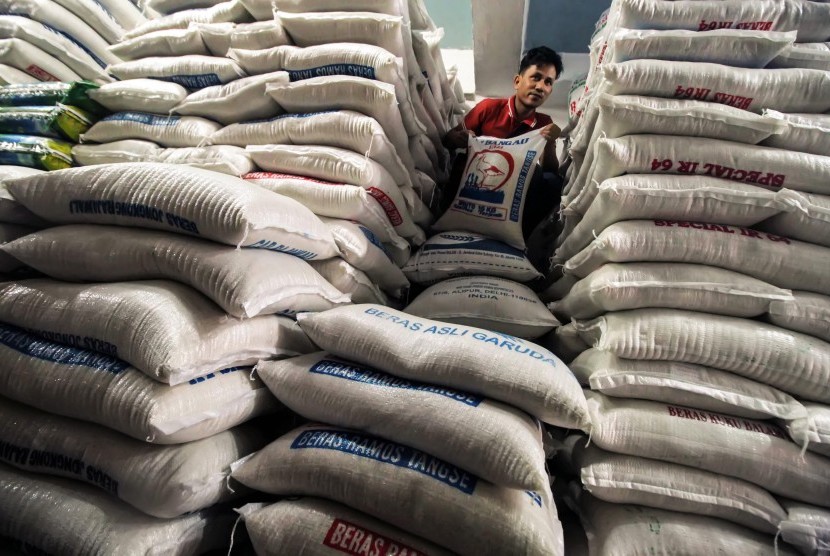 Pedagang mengangkut beras kelas medium pesanan pembeli di pusat grosir beras, Lhokseumawe, Aceh, Kamis (24/1/2019). 