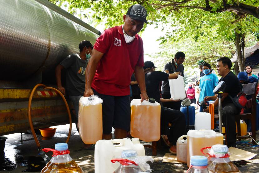 Pedagang mengangkut jeriken berisi minyak goreng curah yang dibeli saat digelar operasi pasar di Pasar Dungus, Kabupaten Madiun, Jawa Timur, Kamis (24/3/2022). ilustrasi