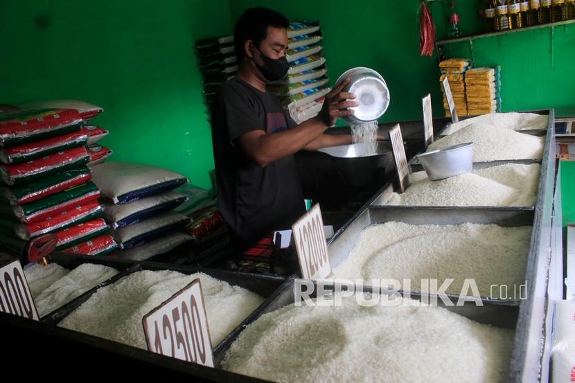 Pedagang mengemas beras pesanan pelanggannya di salah satu agen beras di Surabaya, Jawa Timur.