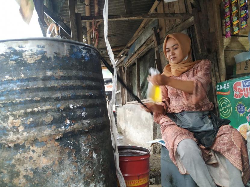 Pedagang mengemas minyak goreng curah di Pasar Cikurubuk, Kota Tasikmalaya, Senin (1/11/2021)