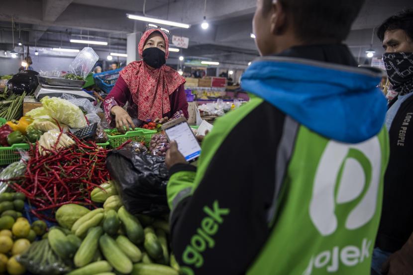Pedagang mengemas pesanan daring sayur-mayur di pasar (ilustrasi)