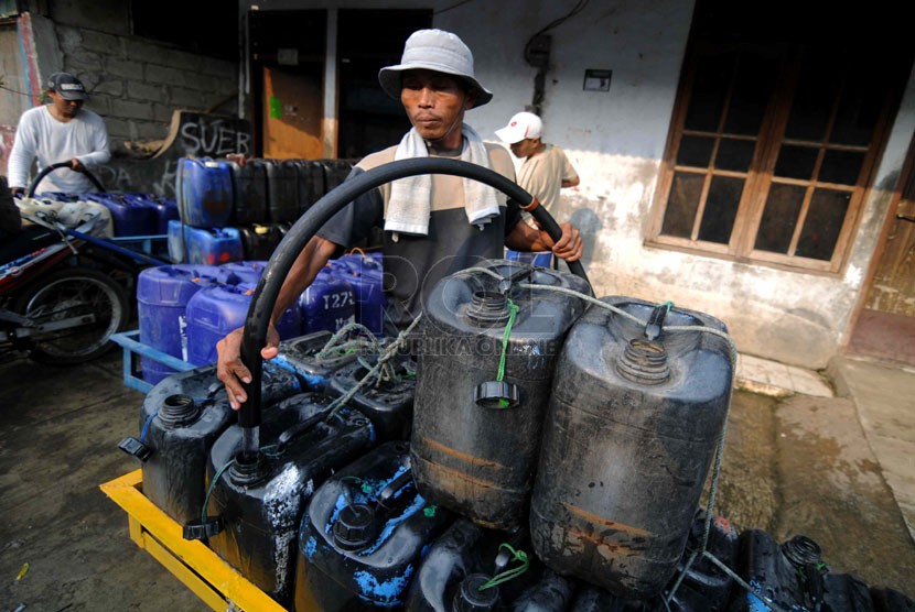 Pedagang mengisi jerigen dengan air bersih di kawasan Muara Baru, Jakarta, Jumat (21/3). (Republika/Wihdan)