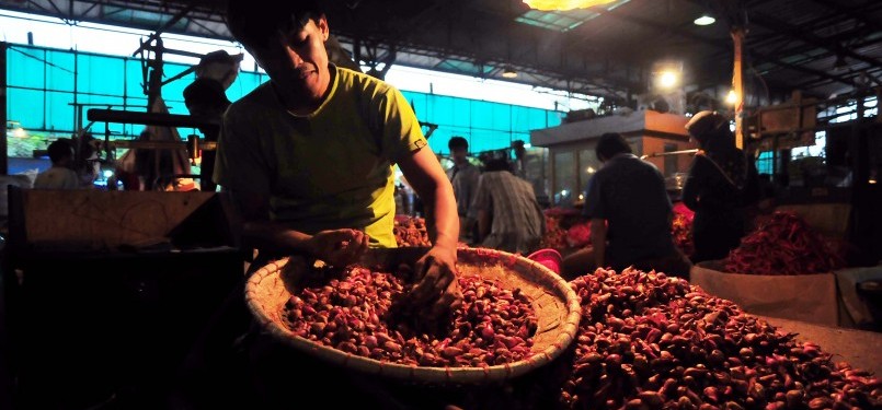 Pedagang mengupas bawang merah sebelum dijual di Pasar Induk Kramat Jati, Jakarta, Ahad (29/1). (Republika/Edwin Dwi Putranto)