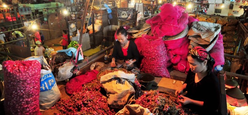 Pedagang mengupas bawang merah sebelum dijual di Pasar Induk Kramat Jati, Jakarta, Ahad (29/1). (Republika/Edwin Dwi Putranto)