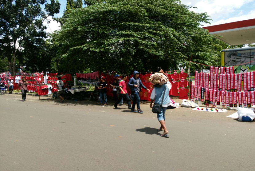 Pedagang menjual atribut Timnas Indonesia jelang laga Indonesia melawan Thailand di sepanjang jalan Stadion Pakansari.