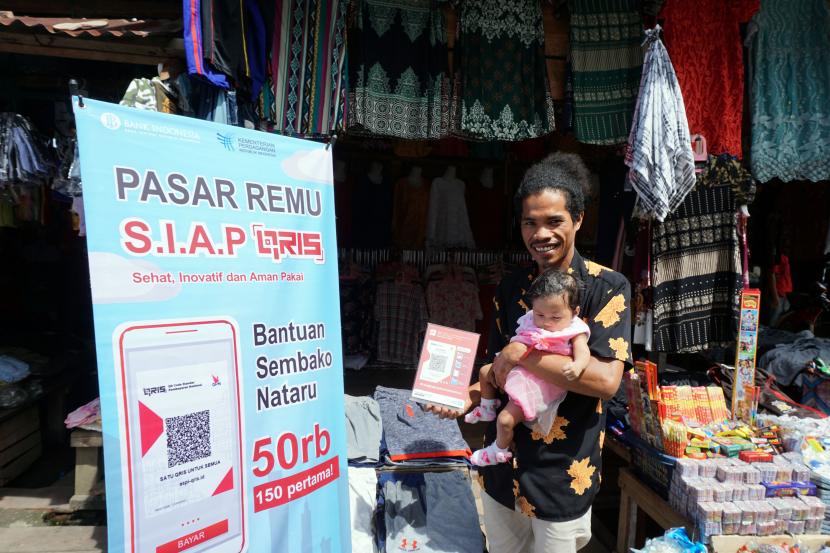Pedagang menunjukan barcode Quick Response Code Indonesian Standard (QRIS) saat transaksi non tunai di Pasar Remu Kota Sorong, Papua Barat, Kamis (2/12/2021) (ilustrasi).