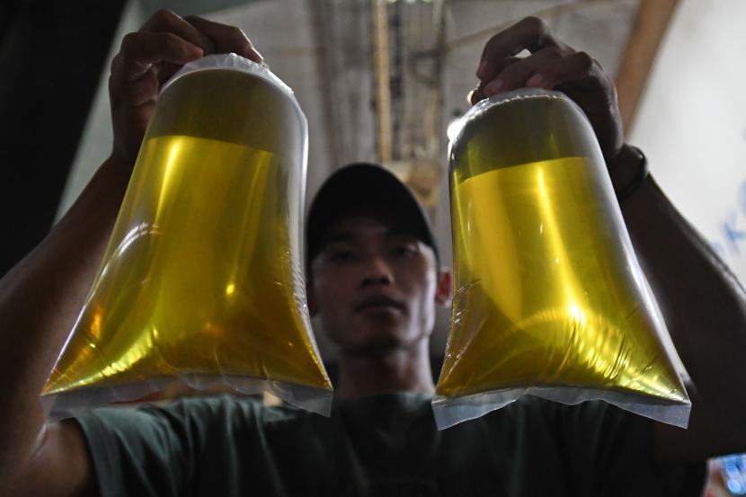 Pedagang menunjukkan plastik berisi minyak goreng curah di Pasar Senen, Jakarta, Selasa (31/5/2022). Kementerian Perindustrian mencabut subsidi minyak goreng curah kepada pelaku usaha mulai Selasa (31/5/2022) menyusul dikeluarkannya Permendag Nomor 30 Tahun 2022 yang mengatur ketentuan ekspor CPO dan turunan lainnya dan Permendag Nomor 33 Tahun 2022 tentang Tata Kelola Minyak Goreng Curah Sistem DMO-DPO. 