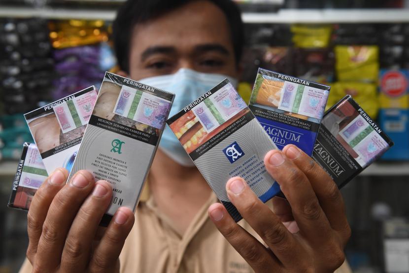 Pedagang menunjukkan rokok di kiosnya, Jakarta, Selasa (14/12/2021). Pemerintah menetapkan, kenaikan tarif rata-rata cukai hasil tembakau (CHT) pada tahun 2022 sebesar 12%. 