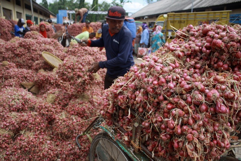 Pedagang menurunkan bawang merah, ilustrasi