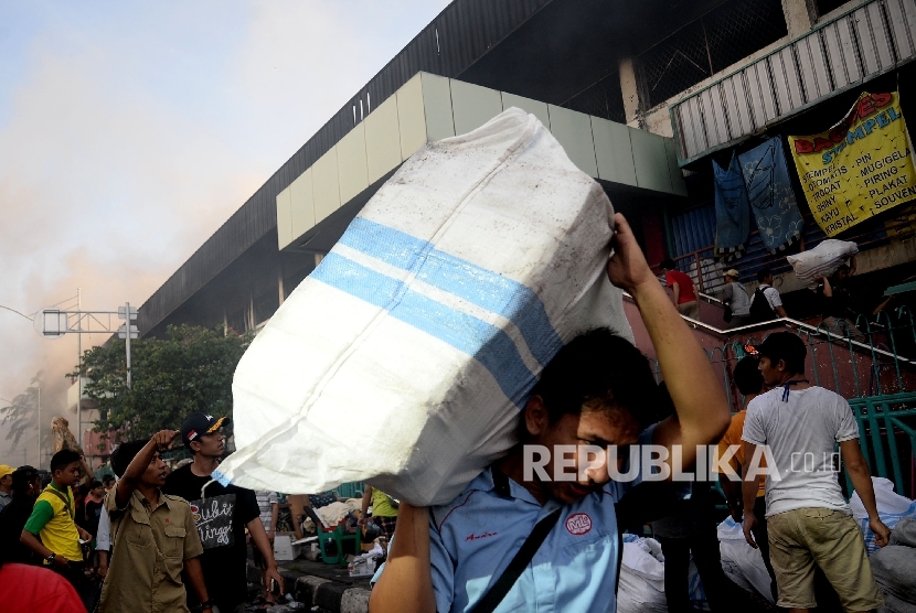  Pedagang menyelamatkan barang-barangnya dari lokasi Blok I dan Blok II Pasar Senen yang terbakar di Jakarta, Kamis (19/1).