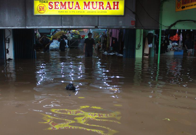 Pedagang menyelamatkan barang dagangan saat banjir merendam kiosnya di Pasar Raya Cipulir, Jakarta Selatan, Sabtu (20/2/2021). Banjir yang disebabkan luapan Kali Pesanggrahan akibat hujan di wilayah Jabodetabek pada Jumat (19/2) malam itu menyebabkan aktivitas jual beli terganggu.
