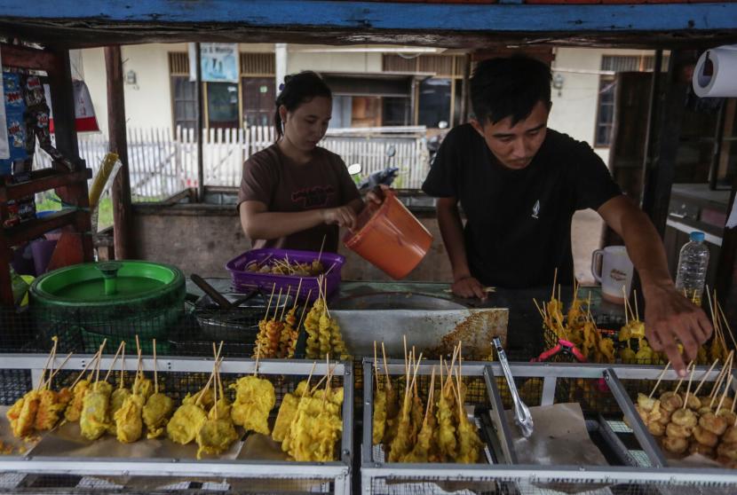 Pedagang menyiapkan makanan gorengan pada lapak dagangannya di Jalan Sisingamangaraja, Palangkaraya, Kalimantan Tengah, Sabtu (2/4/2022). Pemerintah akan menyalurkan bantuan langsung tunai (BLT) minyak goreng pada bulan April 2022 sebesar Rp300 ribu untuk 20,5 juta keluarga yang terdaftar dalam program bantuan pangan non-tunai (BPNT) dan keluarga harapan (PKH) serta kepada 2,5 juta pedagang kaki lima (PKL) yang berjualan makanan gorengan