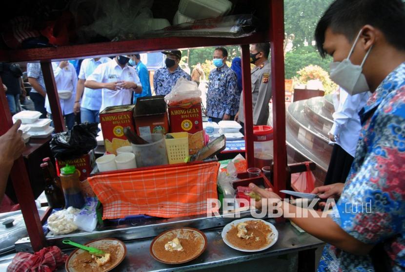 Pedagang menyiapkan makanan ketoprak saat pembagian bantuan makanan untuk warga yang sedang isolasi mandiri (isoman) di halaman Gedung Brajamustika, Kota Bogor, Jawa Barat, Jumat (6/8/2021). Pembagian bantuan makanan dengan memberdayakan pelaku UMKM Kota Bogor yang diadakan Kamar Dagang dan Industri (Kadin) Kota Bogor tersebut sebagai bentuk kepedulian untuk membantu warga yang sedang isoman dan kurang mampu di masa pandemi COVID-19. 