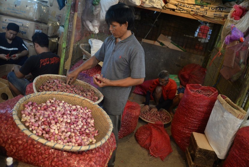 Pedagang menyortir bawang merah di Pasar Induk Kramat Jati, Jakarta, Selasa (29/5). Pemerintah akan membangun lima pasar induk pada tahun depan.