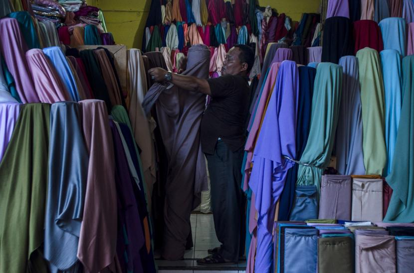 Pedagang merapikan produk tekstil yang dijual di Kampung Wisata Kreatif Tekstil Cigondewah, Bandung, Jawa Barat, Rabu (29/6/2022). Pertumbuhan ekonomi nasional mencapai 5,44 persen pada kuartal II 2022. 