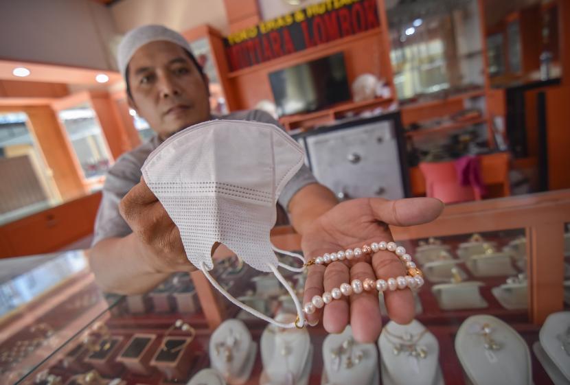 Pedagang mutiara menunjukkan produk konektor masker yang berbahan mutiara yang dijual di pusat kerajinan mutiara Lombok di Kecamatan Sekarbela, Mataram, NTB, Senin (15/3/2021). Nilai ekspor mutiara NTB mencapai Rp 82 miliar sepanjang 2021.  
