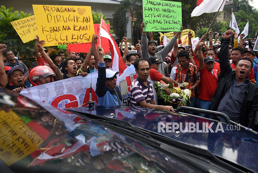 Pedagang Pasar Kemiri Muka membawa poster dan barang dagangan mereka saat menggelar aksi unjuk rasa menolak eksekusi lahan pasar di depan Pengadilan Negeri Kota Depok, Jawa Barat, Senin (16/4).