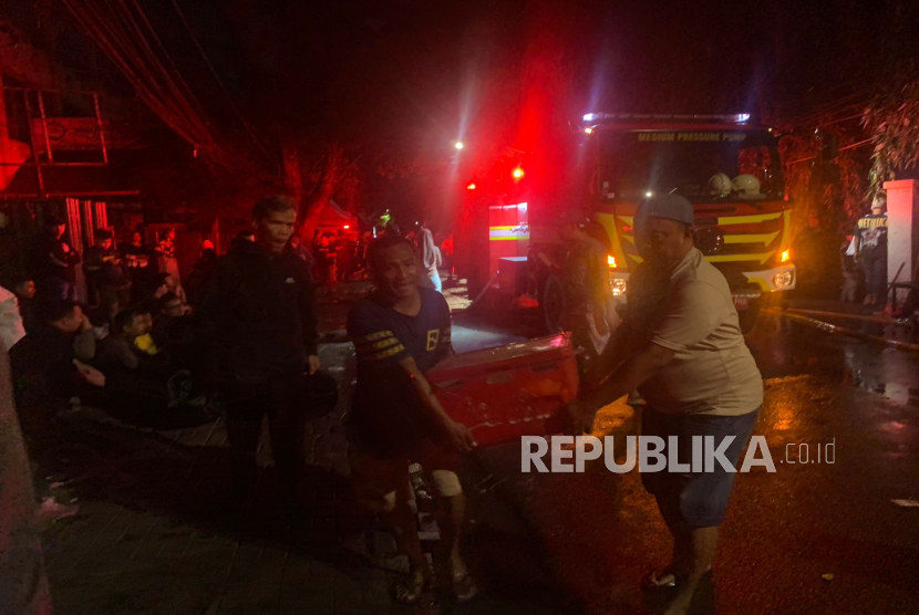 Pedagang Pasar Taman Puring mencoba menyelamatkan sisa-sisa barang dagangannya setelah peristiwa kebakaran pada Senin (28/7/2025).