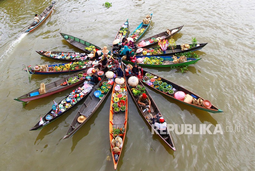 Pedagang Pasar Terapung melakukan atraksi Jukung (perahu) di Desa Lok Baintan, Kabupaten Banjar, Kalimantan Selatan.