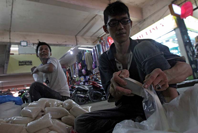 Pedagang saat menimbang gula pasir di Pasar palmerah, Jakarta, Kamis (12/6).