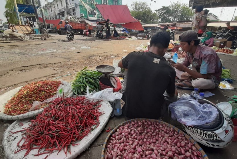 Pedagang sayuran sedang menunggui lapaknya yang sepi pengunjung di Pasar Baru Bekasi, Bekasi Timur, Kota Bekasi.