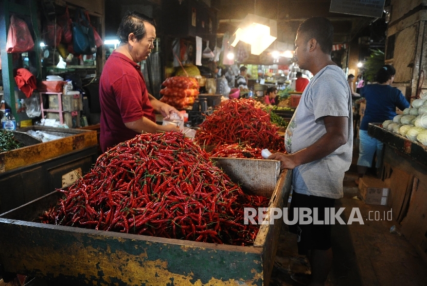  Pedagang sedang melayani pembeli cabai rawit merah di pasar tradisional, Jakarta, Senin (2\1). 