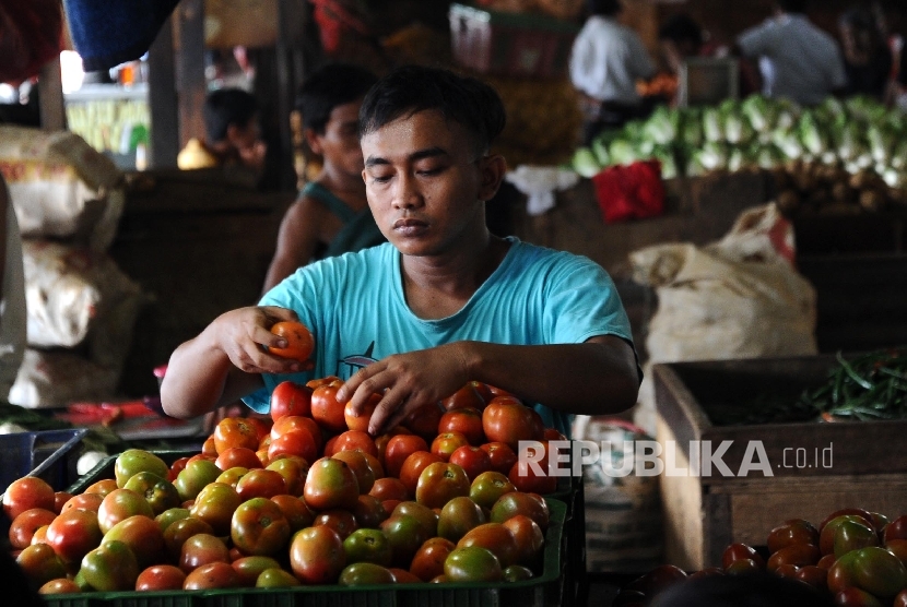  Pedagang sedang memilah tomat di pasar tradisional, Jakarta, Jumat (15/4). 