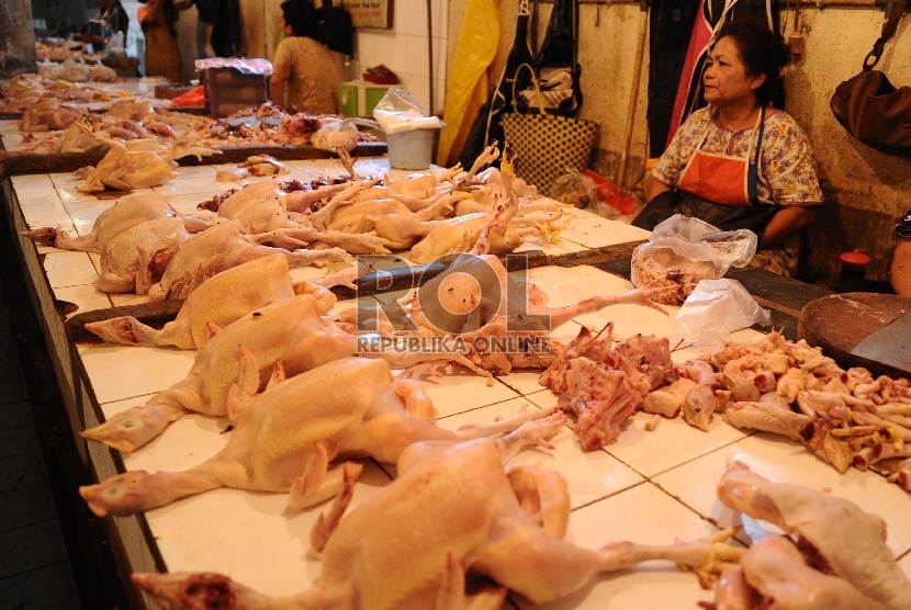 Pedagang sedang memotong ayam dilapak tempat berjualan di pasar tradisional, Jakarta, Selasa (4/8). 