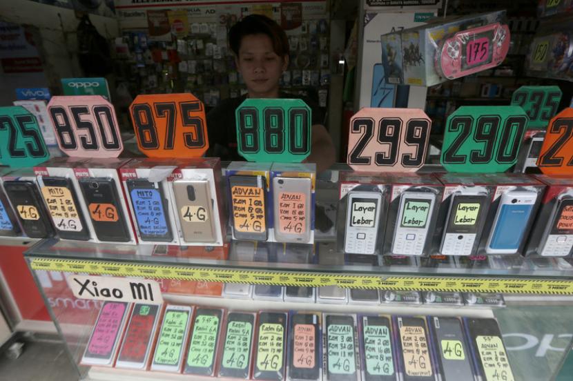 Pedagang smartphone menunggu lapaknya di Jakarta, Indonesia.