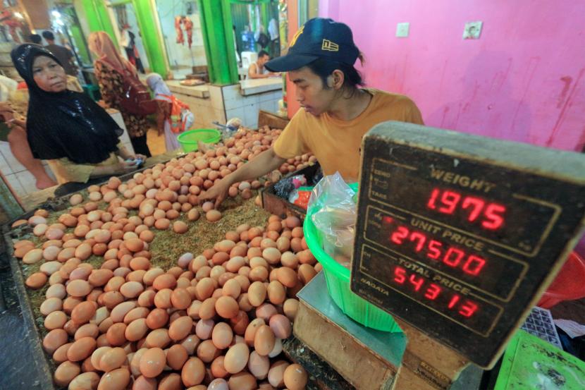 Pedagang telur melayani pembeli di Pasar Cibinong, Kabupaten Bogor, Jawa Barat, Rabu (25/5/2022). Harga telur ayam ras di pasar itu mengalami kenaikan dari Rp 22 ribu per kilogram menjadi Rp27 ribu per kilogram yang disebabkan naiknya harga pakan ayam.