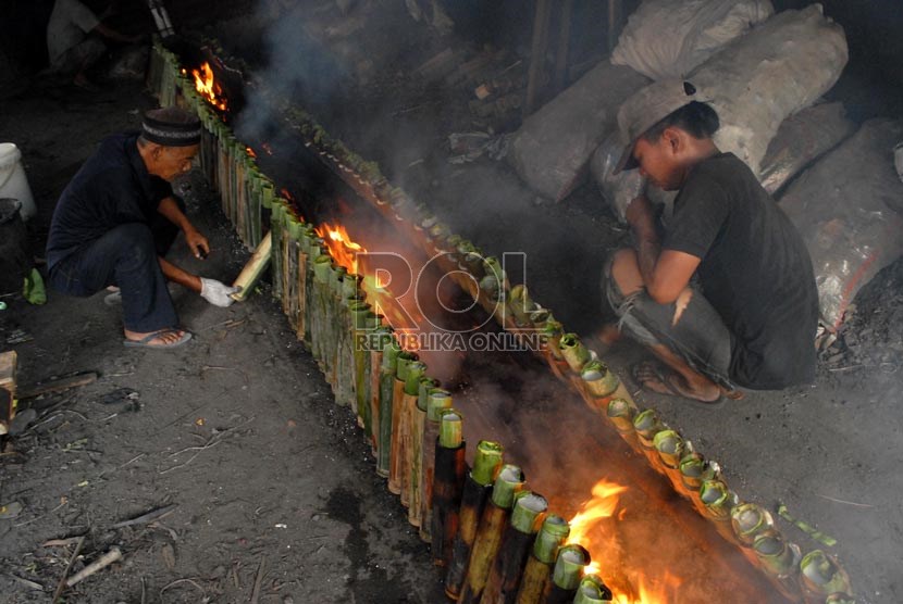  Pedagang tengah memasak Lemang menggunakan kayu bakar di kawasan Kramat, Senen, Jakarta Pusat, Selasa (23/7).    (Republika/Rakhmawaty La'lang)