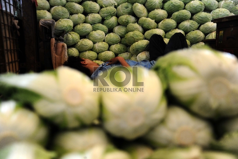 Pedagang tertidur diantara sayur mayur di pasar Induk Kramat Jati, Jakarta, Kamis (23/7).