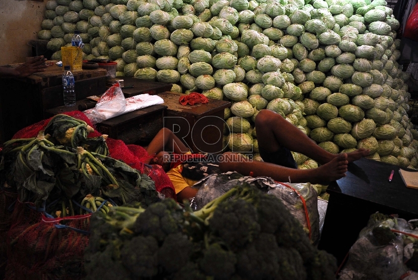 Pedagang tertidur diantara sayur mayur di pasar Induk Kramat Jati, Jakarta, Kamis (23/7).