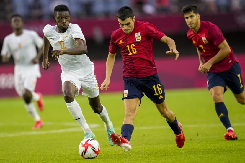 Pedri Gonzalez (16) dari Spanyol dan Eboue Kouassi dari Pantai Gading memperebutkan bola dalam pertandingan sepak bola perempat final putra di Olimpiade Musim Panas 2020, Sabtu, 31 Juli 2021, di Rifu, Jepang, Tokyo. 