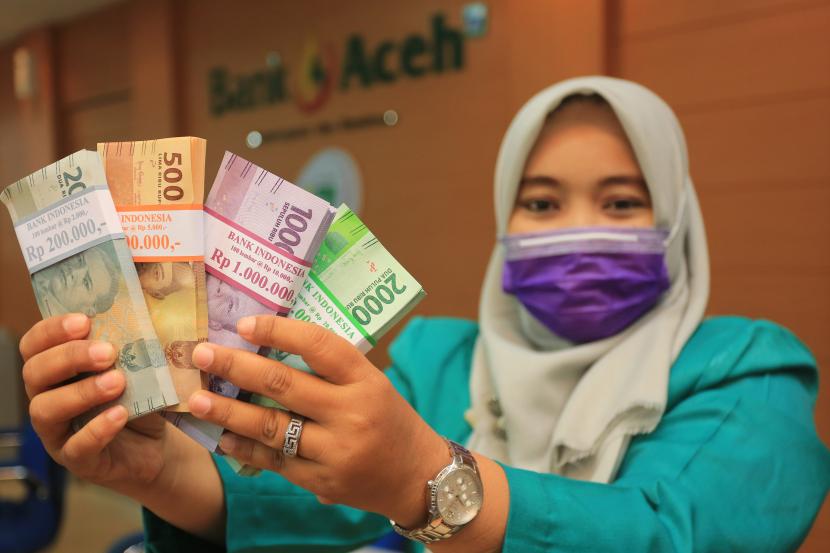 Pegawai Bank Aceh Syariah (BAS) Cabang Meulaboh menunjukan uang pecahan kecil di Meulaboh, Aceh Barat, Aceh, Rabu (28/4/2021). Bank Indonesia menyiapkan layanan penukaran uang di 4.608 kantor cabang bank umum di seluruh wilayah Indonesia untuk mempermudah masyarakat dalam mendapatkan uang pecahan selama Ramadhan dan Lebaran yang dimulai sejak 12 April hingga 11 Mei 2021 mendatang.