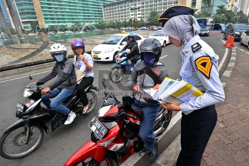  Pegawai kemenhub membagikan peta jalur mudik kepada pengendara di Bundaran HI, Jakarta, Selasa (30/7). (Republika/ Tahta Aidilla)