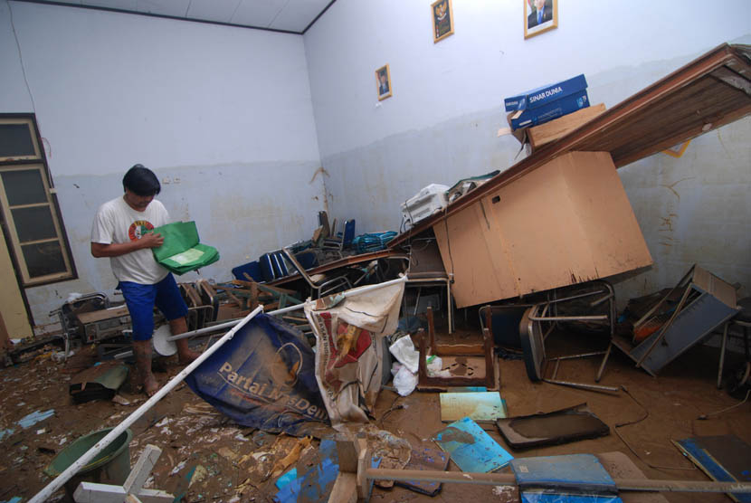 Pegawai KPU mencari dokumen yang masih dapat diselamatkan pasca banjir di kantor KPU Manado, Sulawesi Utara, Senin (20/1). (Antara/Fiqman Sunandar)