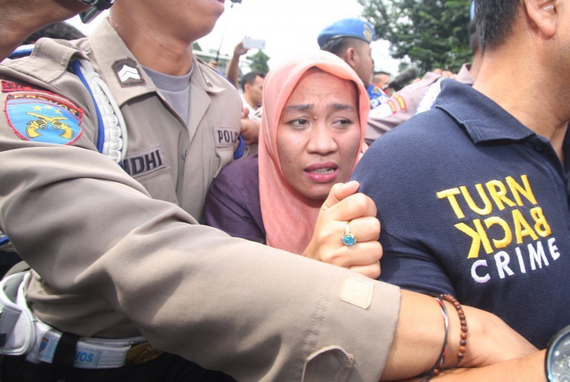 Pegawai Mahkamah Agung Dora Natalia Singarimbun (tengah) menghindar pertanyaan wartawan usai menjalani pemeriksaan di Polres Jakarta Timur,Jakarta, Senin (19/12). 